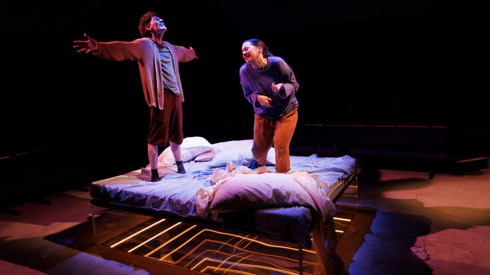 An image of two people dancing on a bed.